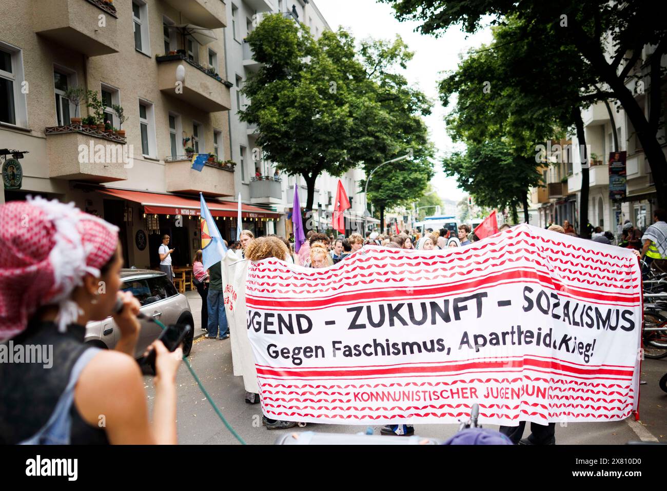 Berlino, Germania. 22 maggio 2024. I partecipanti tengono uno striscione con il testo "Gioventù - futuro - socialismo contro il fascismo, l'apartheid e la guerra!" Durante la manifestazione "sciopero scolastico per la Palestina" di fronte alla scuola Rütli di Neukölln. Credito: Carsten Koall/dpa/Alamy Live News Foto Stock