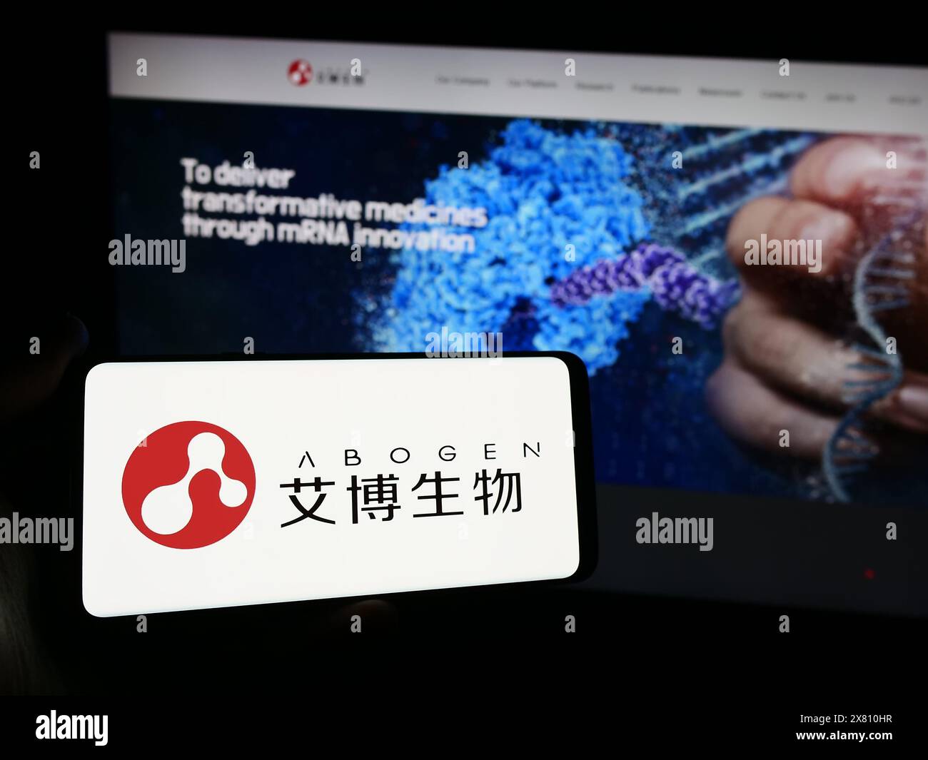 Persona che detiene lo smartphone con il logo della società cinese Suzhou Abogen Biosciences Co. Ltd. Davanti al sito Web. Mettere a fuoco il display del telefono. Foto Stock