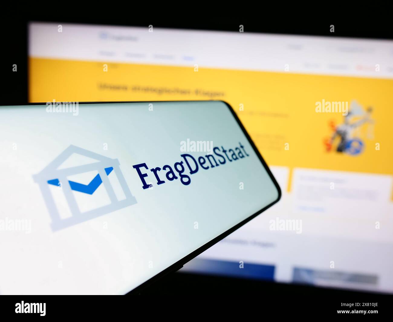 Cellulare con il logo dell'organizzazione non governativa tedesca FragDenStaat davanti al sito web. Mettere a fuoco la parte centrale sinistra del display del telefono. Foto Stock