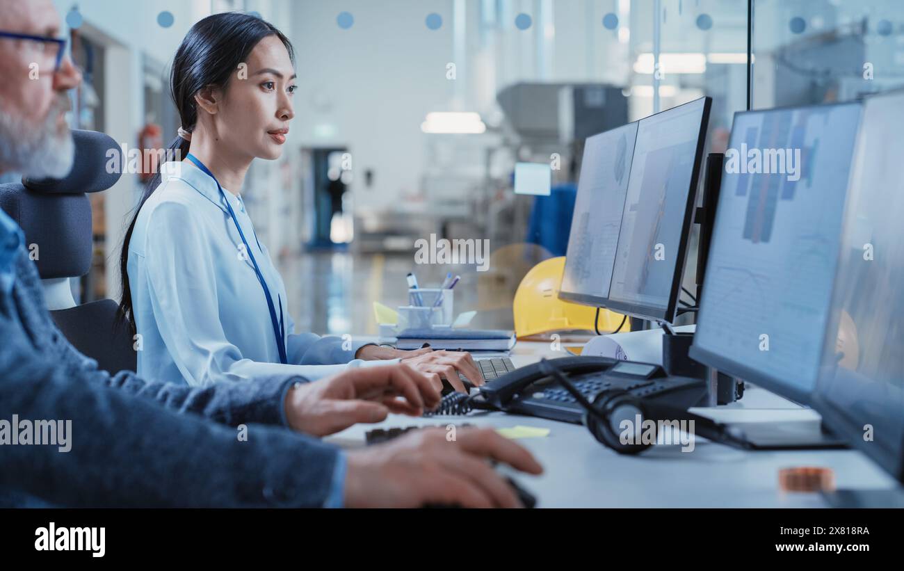 Stabilimento per uffici: Ingegneri industriali che redigono progetti di parti di macchine per l'industria pesante su un software CAD per computer. Centro moderno di ricerca e sviluppo tecnologico. Foto Stock