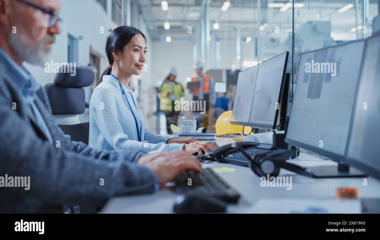 Stabilimento per uffici: Ingegneri industriali che redigono progetti di parti di macchine per l'industria pesante su un software CAD per computer. Centro moderno di ricerca e sviluppo tecnologico. Foto Stock