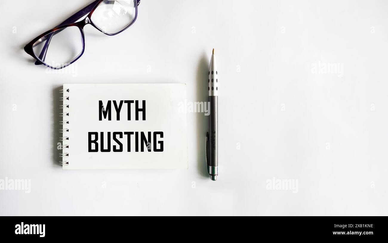 Blocco note con l'iscrizione MITO CHE SI APRE su uno sfondo bianco con una penna e occhiali. Informazioni con spazio di testo per poster didattici o. Foto Stock