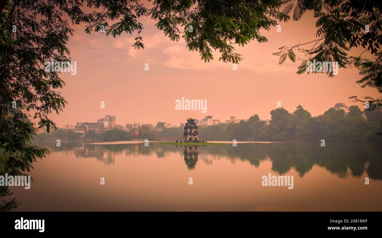 Turtle Tower sul lago Hoan Kiem al tramonto ad Hanoi, Vietnam. Tono vintage Foto Stock