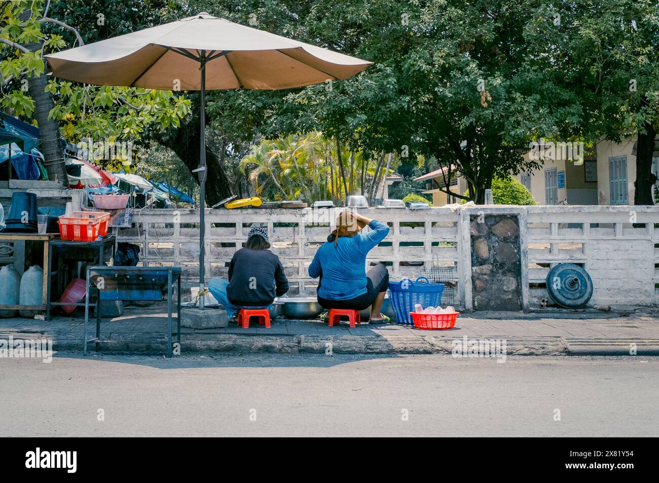 Le donne sul ciglio della strada lavano piatti, Kampot, Cambogia, Asia Foto Stock