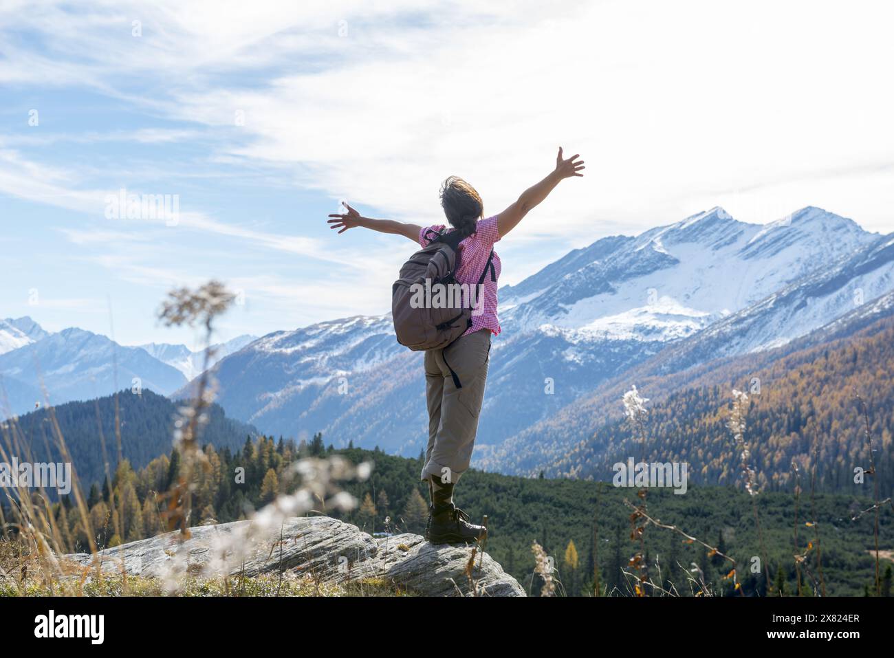 Camminata sulle donne e con le sue braccia allungate e goditi la Scape di montagna con la neve a San Bernardino, Grigioni, Svizzera. Foto Stock