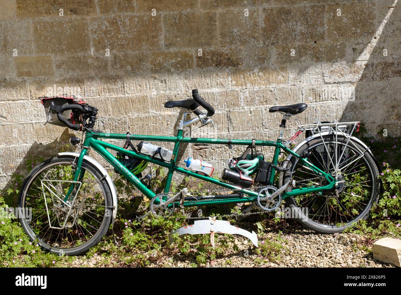 Un tendem una bicicletta per due persone appoggiata contro un muro a Bisley, nelle Cotswolds Foto Stock