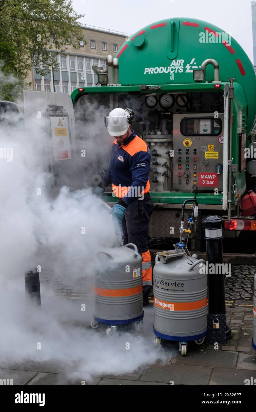 Operatore di prodotti ad aria che riempie le fiasche Dewar con azoto liquido a Bristol Foto Stock