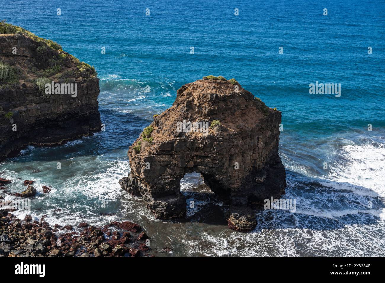 L'arco marino di Roque Chico, un eccellente esempio di erosione costiera causata dall'azione delle onde dal sentiero a piedi Rambla de Castro vicino a Puerto de la Cruz, Tenerife Foto Stock