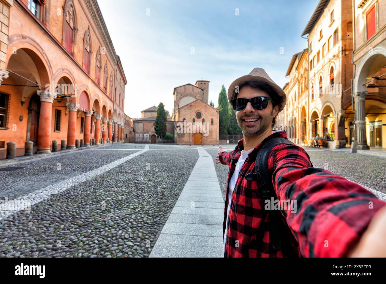 Un turista che scatta selfie nell'affascinante piazza medievale di Bologna, una delle meraviglie d'Italia Foto Stock