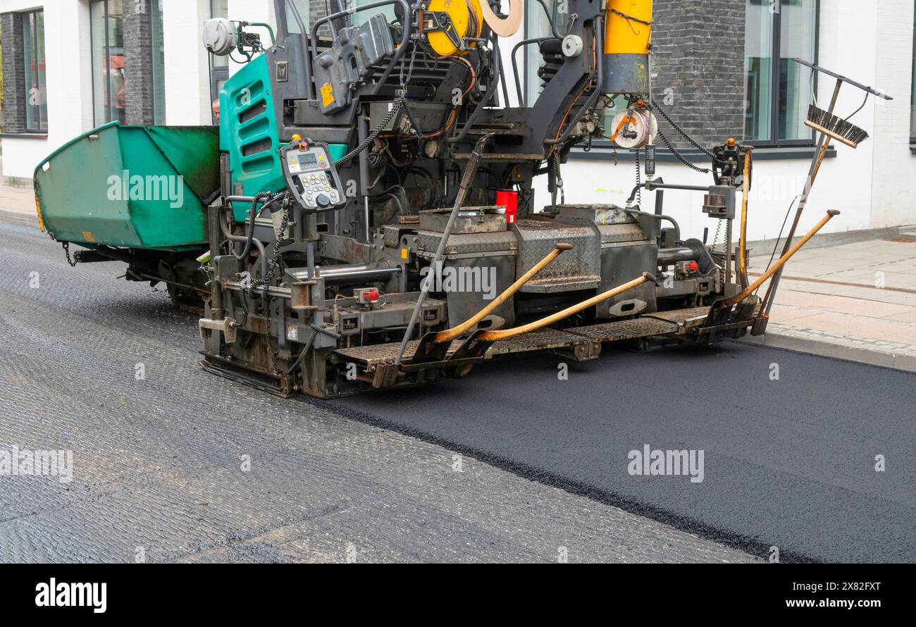 Riparazione della superficie stradale asfaltata - vecchio strato rimosso e rivestimento di un autocarro per pavimentazioni industriale che posa nuovo asfalto sul cantiere. Copenaghen, Foto Stock