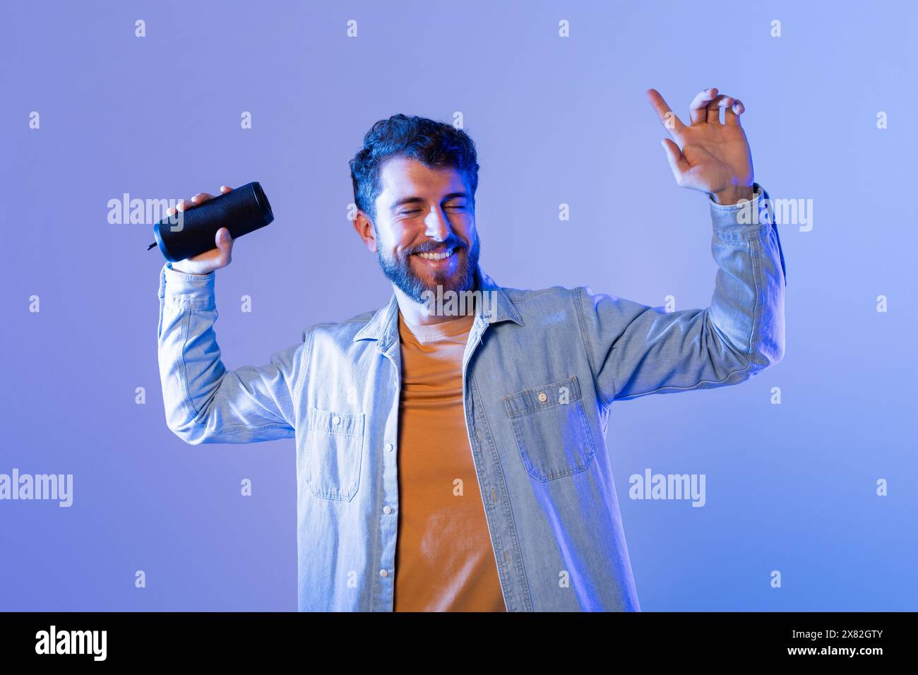 L'uomo ama la musica mentre balla con l'altoparlante Bluetooth Foto Stock