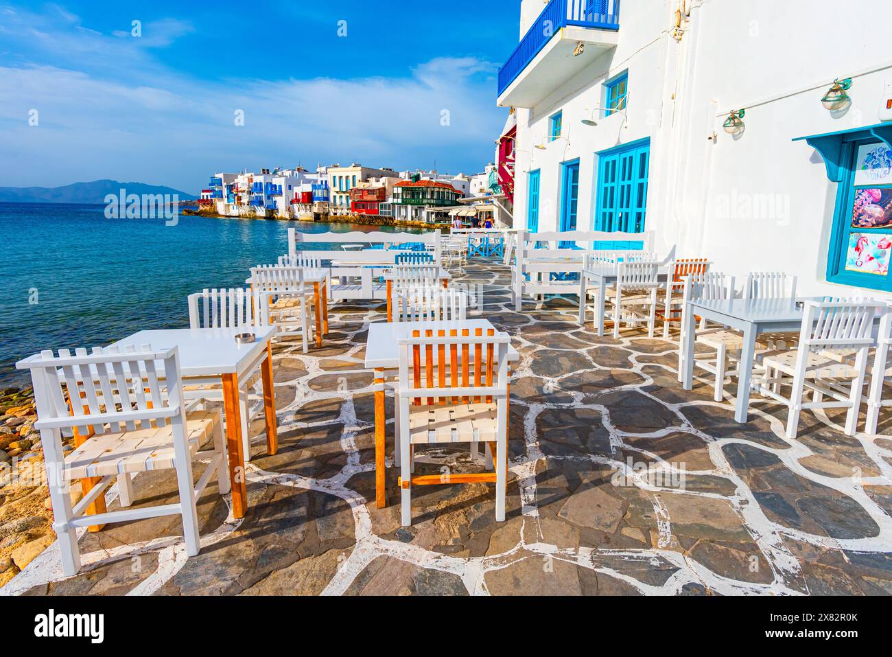 Mykonos, Grecia: Lungomare con tavoli, tipica taverna greca nella parte piccola di Venezia della città di Mykonos, isola di Mykonos, Grecia, destinazione di viaggio in Europa Foto Stock