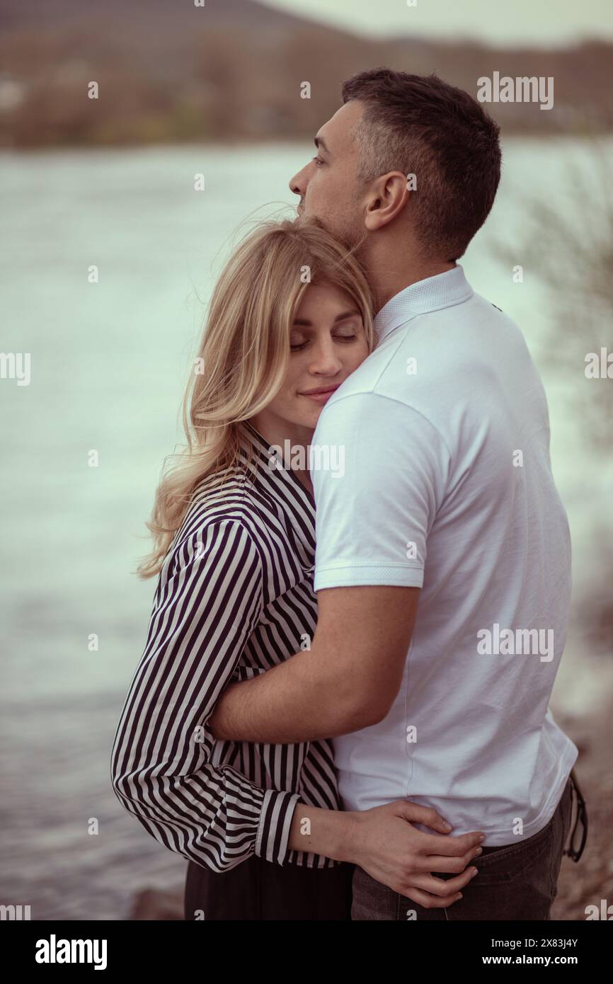 Uomo che abbraccia donna, donna con gli occhi chiusi Foto Stock