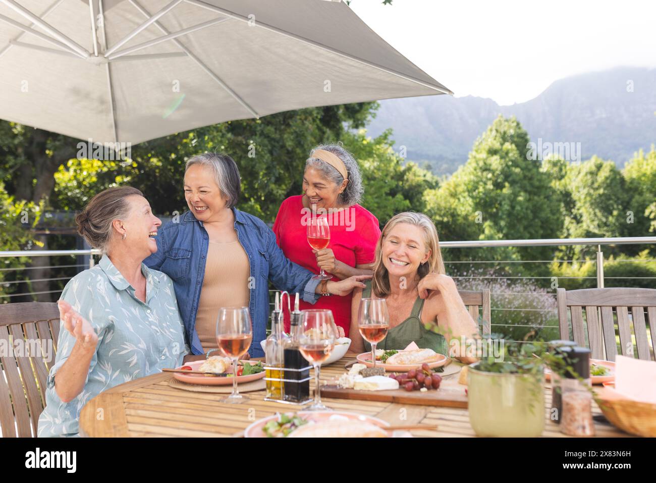 Diverse amiche anziane che ridono di un pasto all'aperto Foto Stock