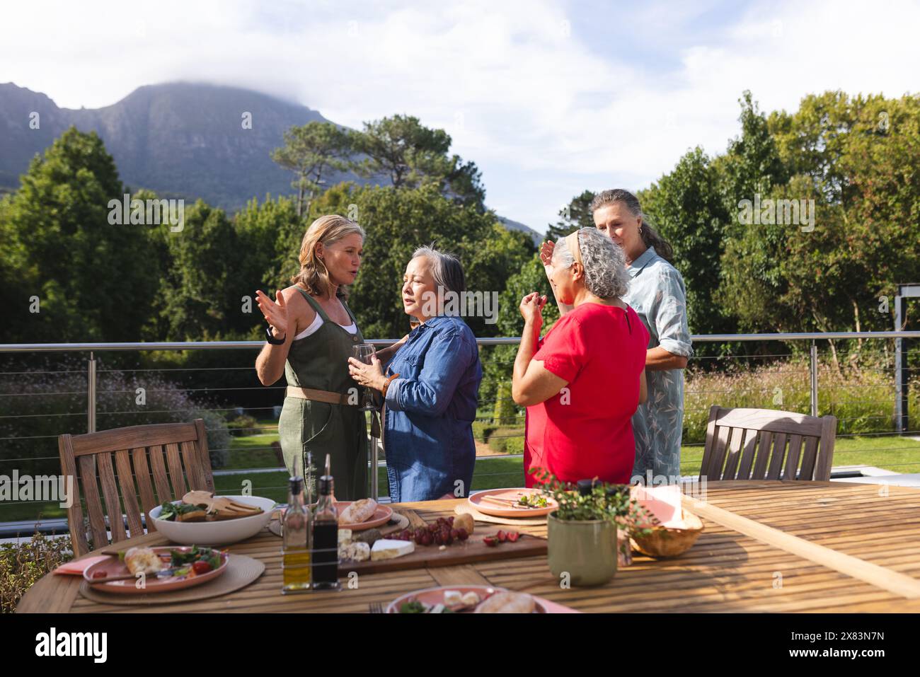 Diverse amiche anziane si godono un pasto all'aperto Foto Stock