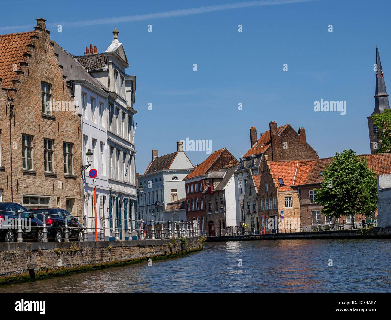 Vista sul centro storico della città lungo un canale con vari edifici, vecchie case storiche con torri e ponti sul canale, Bruges, Belgio Foto Stock