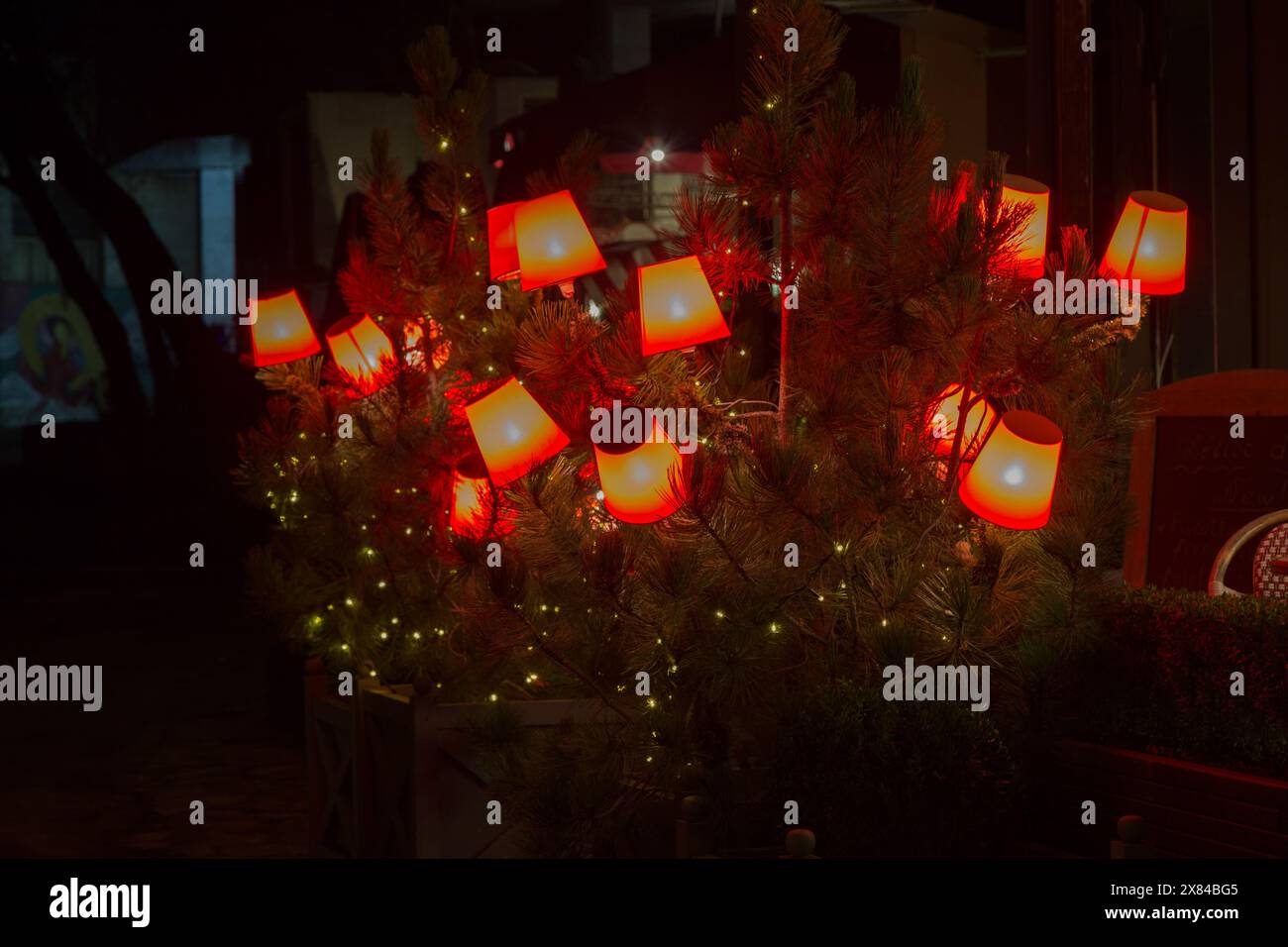 Vedute delle strade di Chisinau di notte. Pine Tree decorato con lampade da terra rosse luminose. Foto Stock