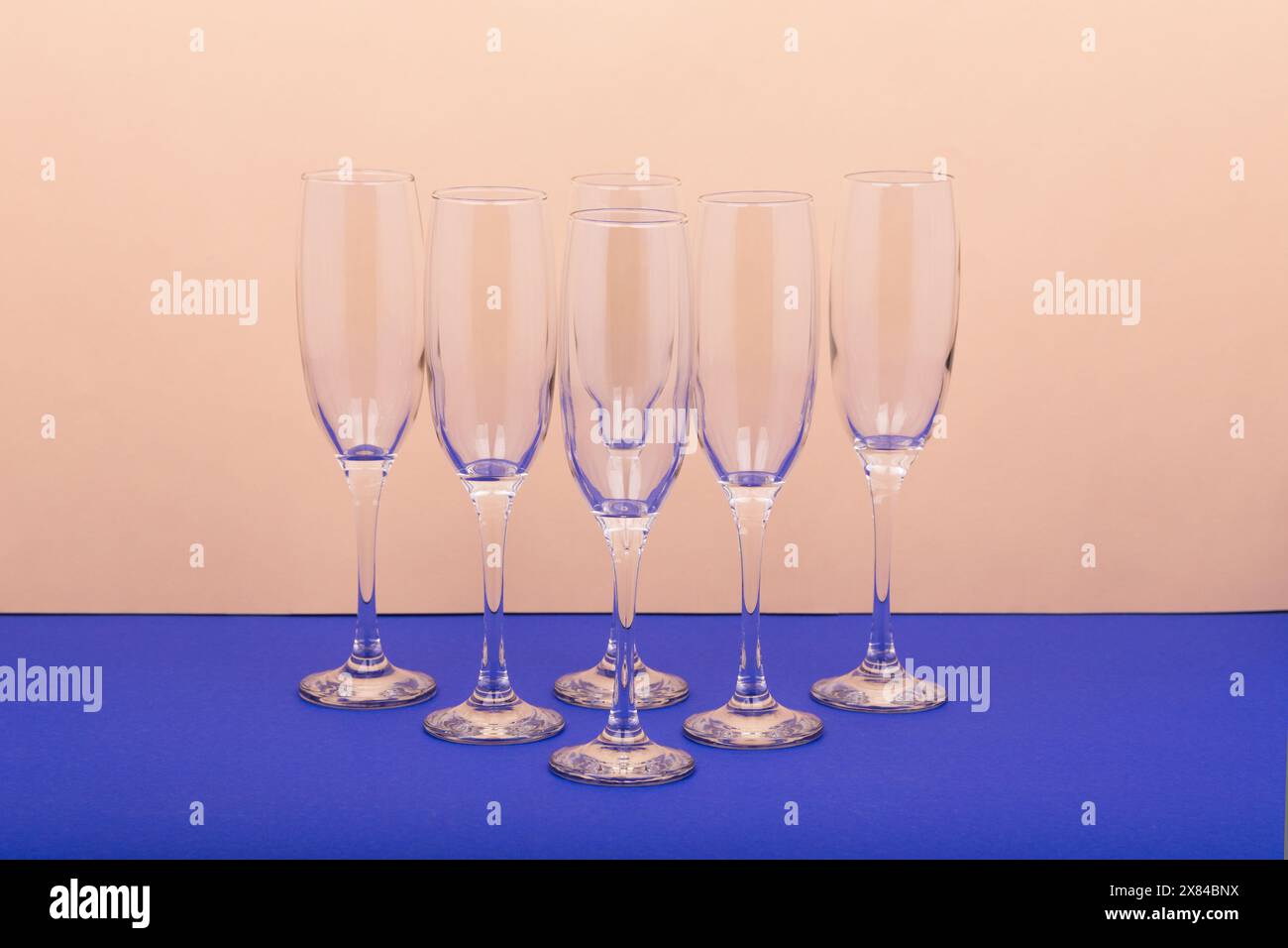 Set di lussuosi bicchieri da champagne in forma triangolare. Concetto di vinificazione e attività di ristorazione. Il colore dello sfondo è la vela champa Foto Stock