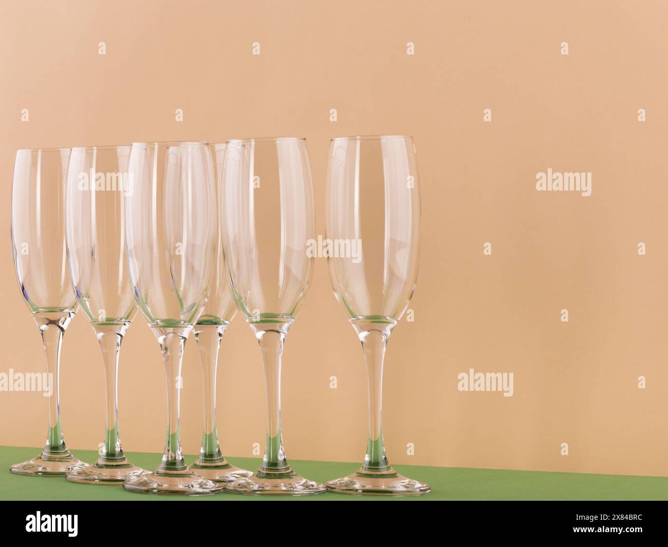 Set di lussuosi bicchieri da champagne in forma triangolare. Concetto di vinificazione e attività di ristorazione. Il colore dello sfondo è la vela champa Foto Stock