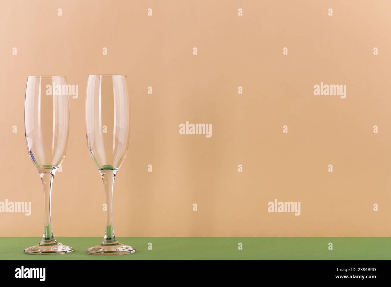 Set di lussuosi bicchieri da champagne in forma triangolare. Concetto di vinificazione e attività di ristorazione. Il colore dello sfondo è la vela champa Foto Stock