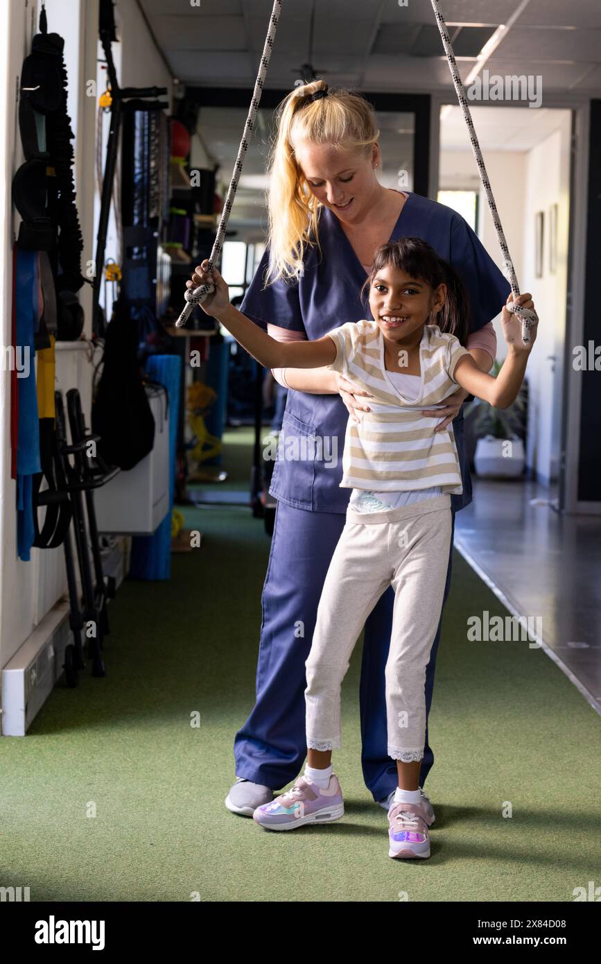 Al centro di riabilitazione, esercizi di fisioterapista donna caucasica con paziente birazziale Foto Stock