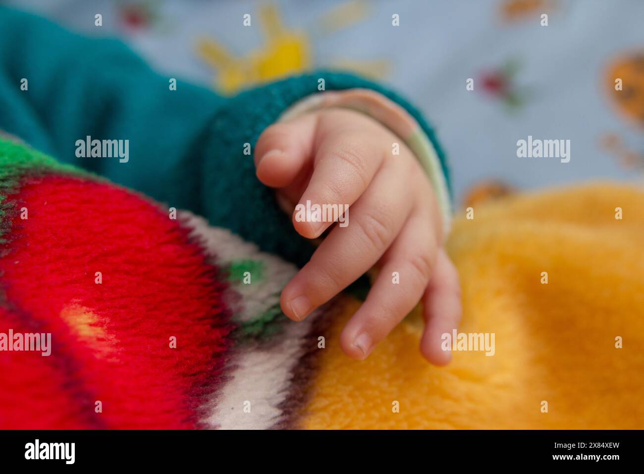 sdraiate il bambino sul letto e la mano è piccola Foto Stock