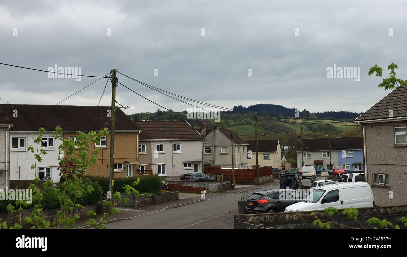 Una vista grandangolare di una strada residenziale in Cross Hands con il versante collinare sullo sfondo. 27 aprile 2024. Cross Hands è un villaggio nel Carmarthenshire, Galles, ed è in un'area di importante patrimonio culturale, culturale e bellezza rurale, conosciuta come la Gwendraeth Valley. Foto Stock