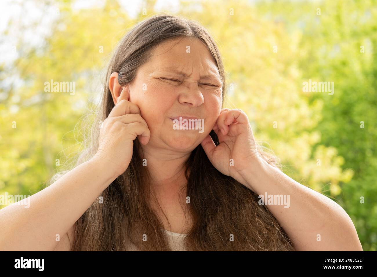 donna matura caucasica tiene l'orecchio doloroso, perdita dell'udito, primo piano del viso, concetto medico, controllo dell'udito, infiammazione dell'orecchio medio, otite media Foto Stock
