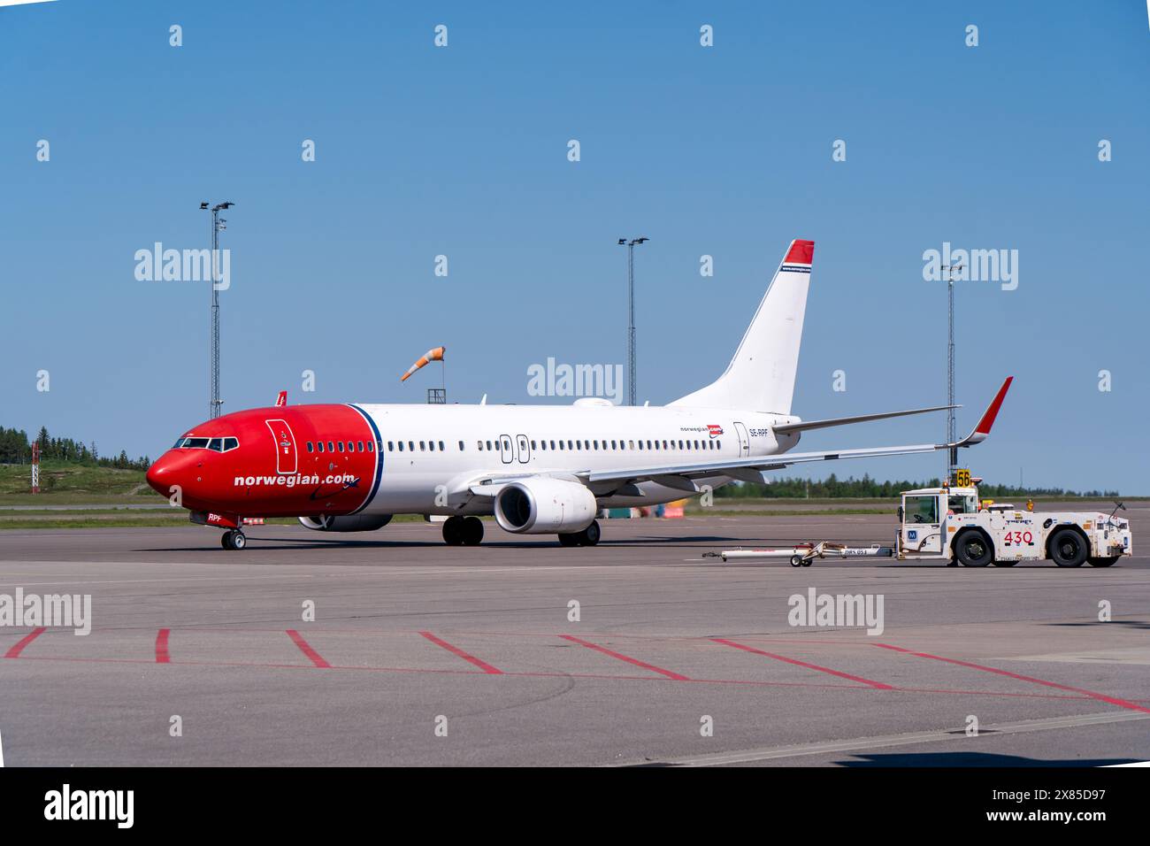 Un boeing 737-800 delle compagnie aeree norvegesi, in tipica livrea rossa e bianca, sull'aeroporto di Gothenburg landvetter, con il camion a spinta nelle vicinanze. S. Brillante Foto Stock