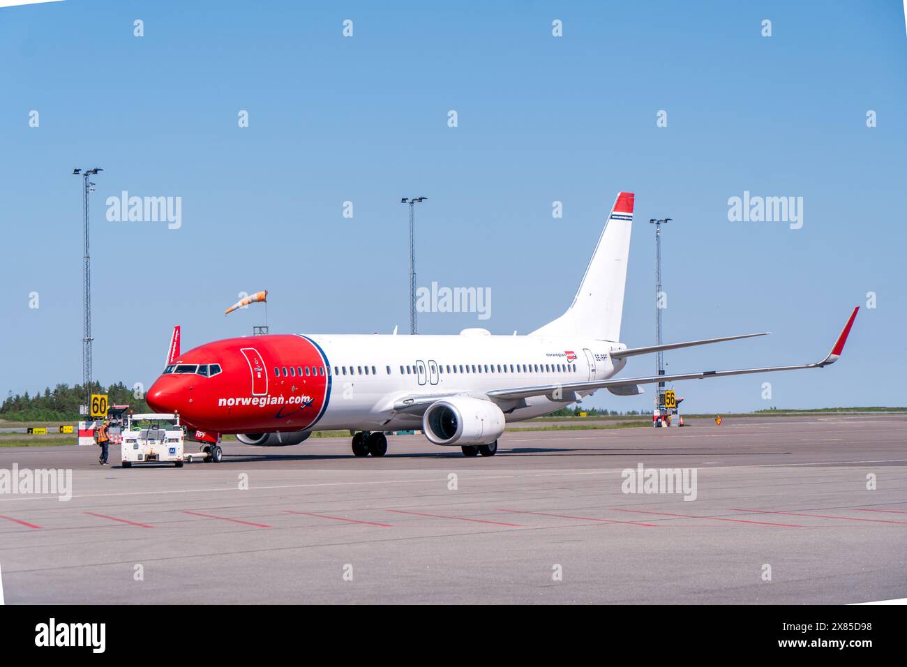Un boeing 737-800 delle compagnie aeree norvegesi, in tipica livrea rossa e bianca, sull'aeroporto di Gothenburg landvetter, con il camion a spinta nelle vicinanze. S. Brillante Foto Stock