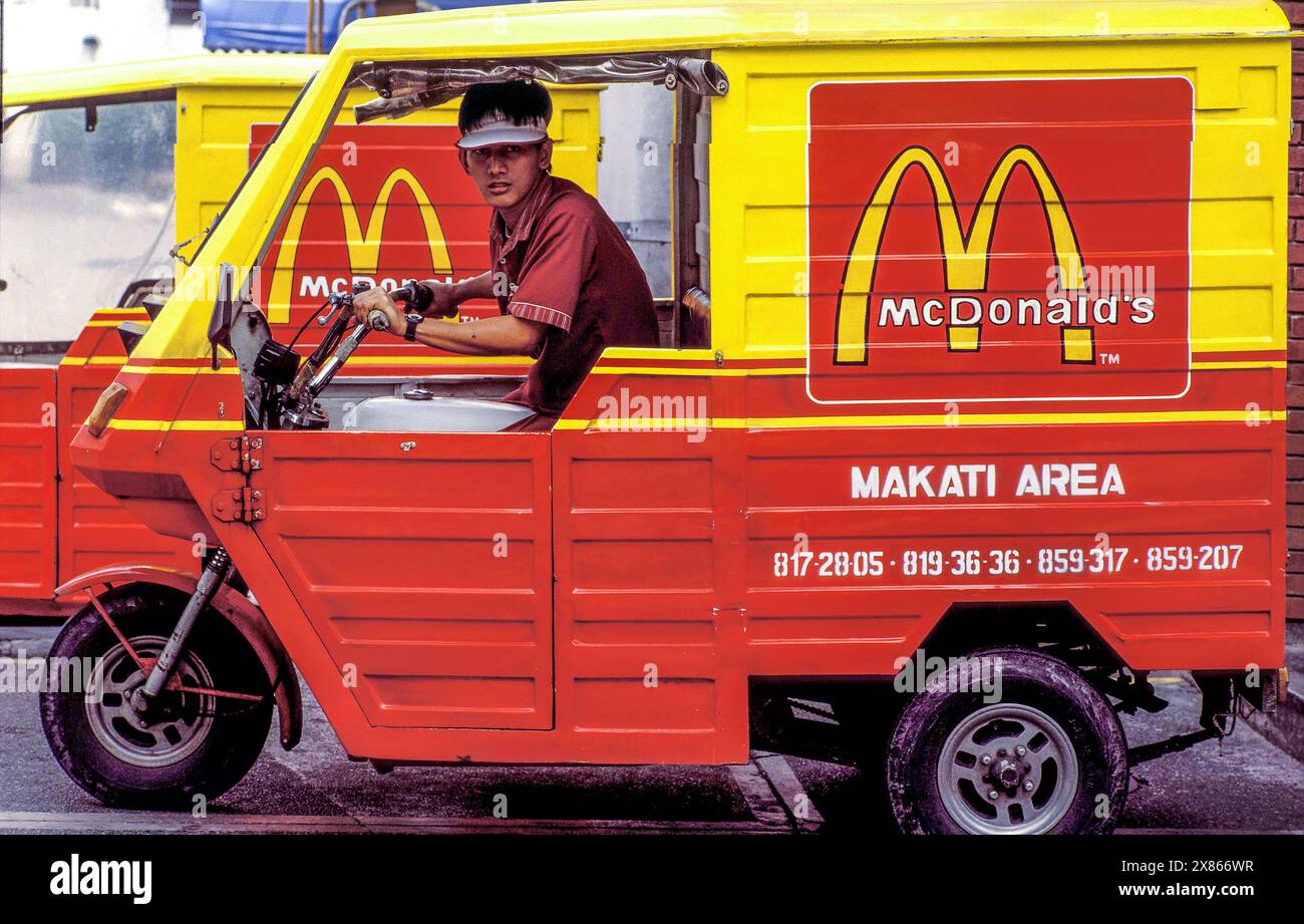 Filippine, Manila; gli ordini McDonald's vengono consegnati nella zona di Makati con uno scooter riksjaw. Foto Stock