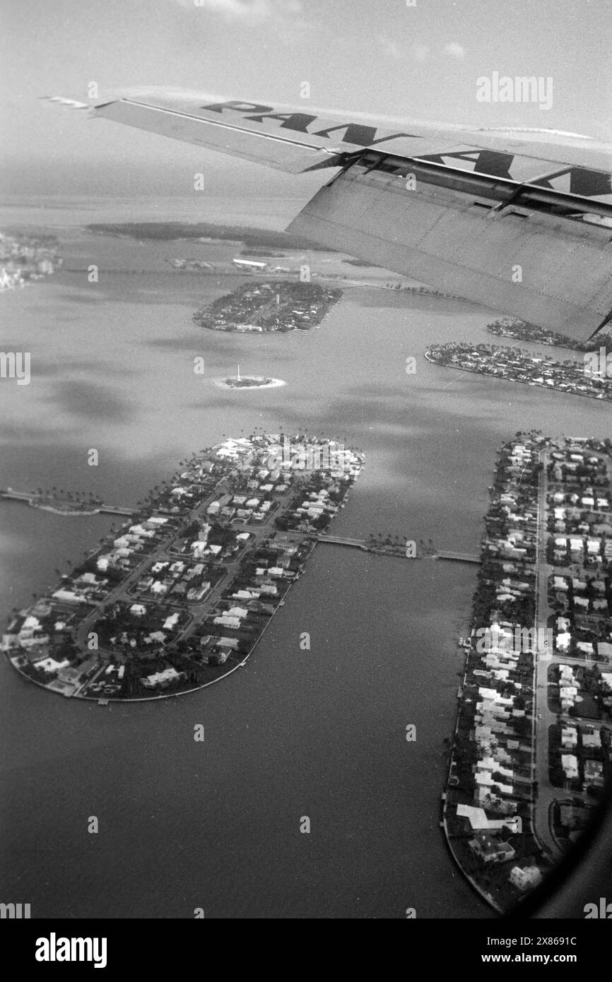 Blick über die Biscayne Bay aus dem Fenster einer Pan Am Machine, im Vordergrund die künstlichen Inseln Rivo alto und di Lido der Gruppe Venetian Islands, sowie die ebenso künstlichen Inseln Flagler Memorial Island, Star, Palm und Hibiscus Island, sowie Fisher Island, Florida 1966. Ammira la baia di Biscayne dalla finestra di una Pan Am Machine, in primo piano le isole artificiali Rivo alto e di Lido del gruppo delle isole veneziane, così come le isole ugualmente artificiali Flagler Memorial Island, Star, Palm e Hibiscus Island, e Fisher Island, Florida 1966. Foto Stock