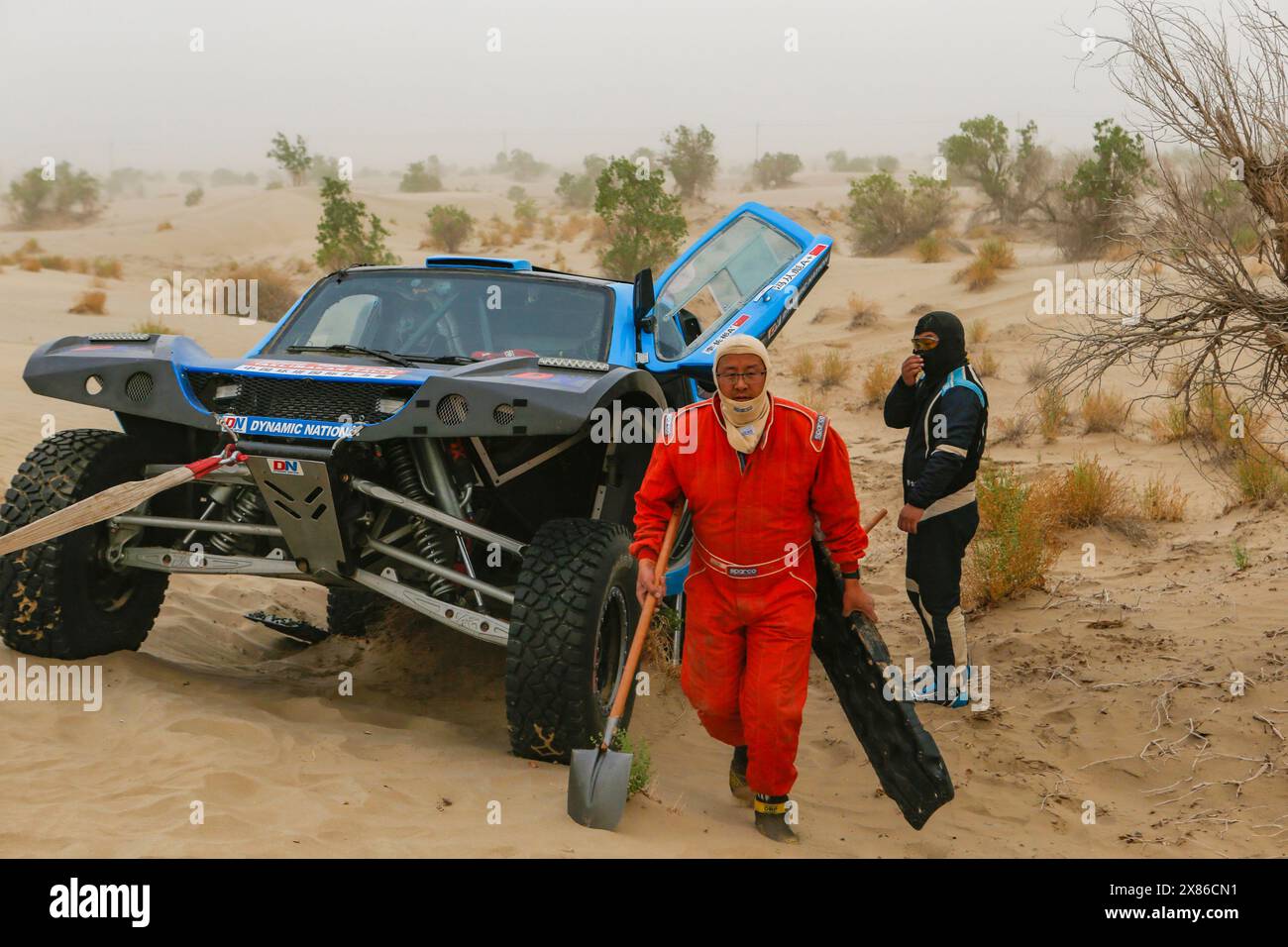 Kashgar, la regione autonoma nordoccidentale dello Xinjiang Uygur in Cina. 23 maggio 2024. Il pilota cinese li Changbin e il suo pilota Feng Congbin (davanti) della Cina ripararono la loro auto durante la terza tappa al Rally Taklimakan 2024 a Kashgar, nella regione autonoma di Xinjiang Uygur, nella Cina nord-occidentale, il 23 maggio 2024. Crediti: Chen Shuo/Xinhua/Alamy Live News Foto Stock