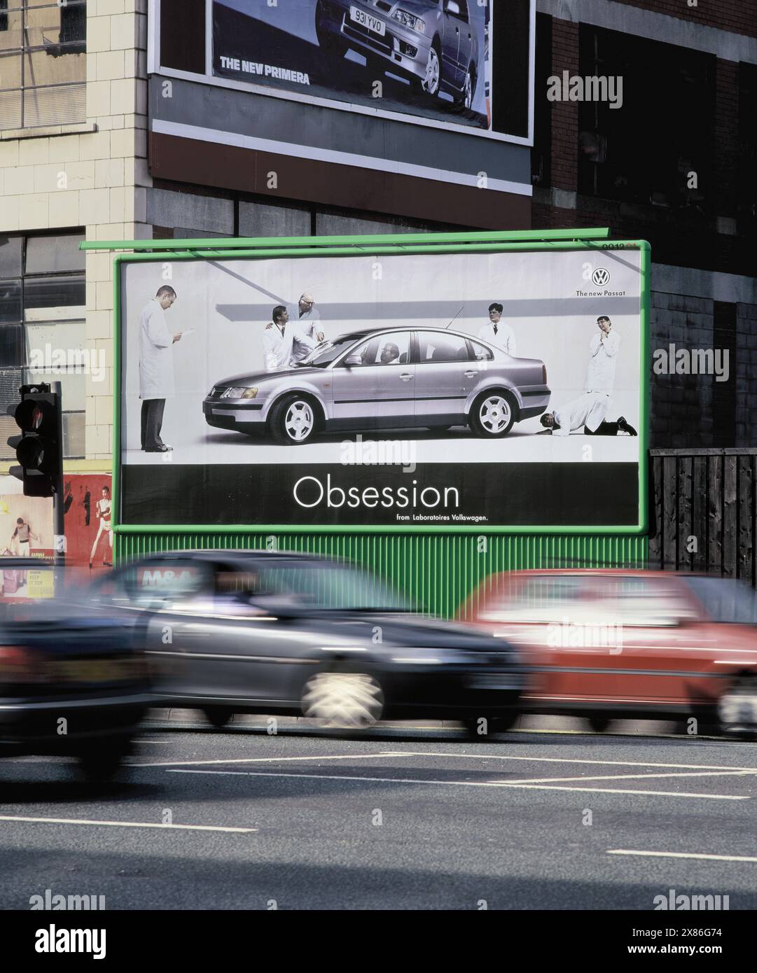 Cultura automobilistica: Annunci di auto che passano per le auto nuove, Great Ancoats Street, Manchester. Foto Stock