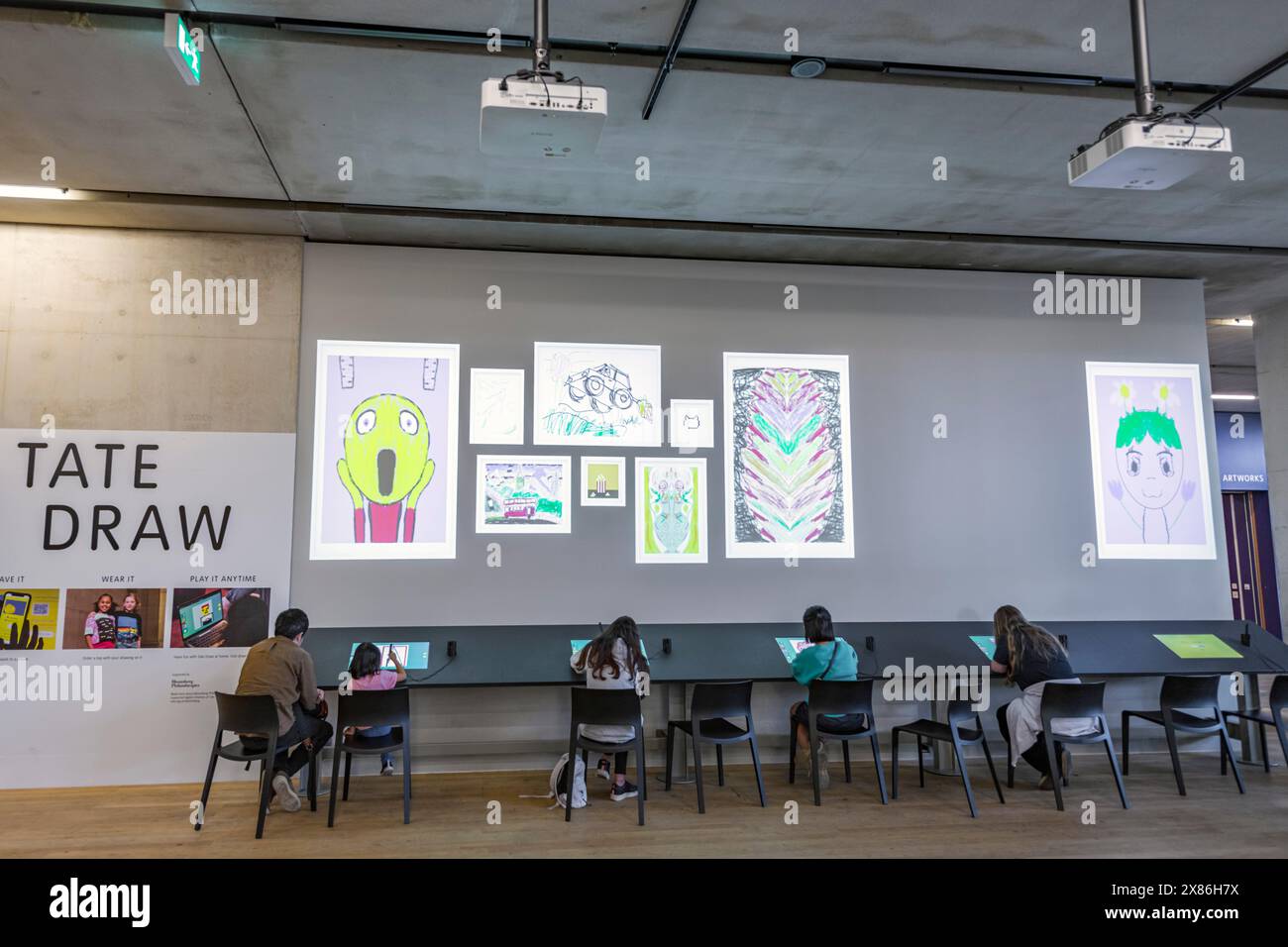 Giovani che usano i tablet per disegnare e proiettare sul muro al Tate Modern Foto Stock