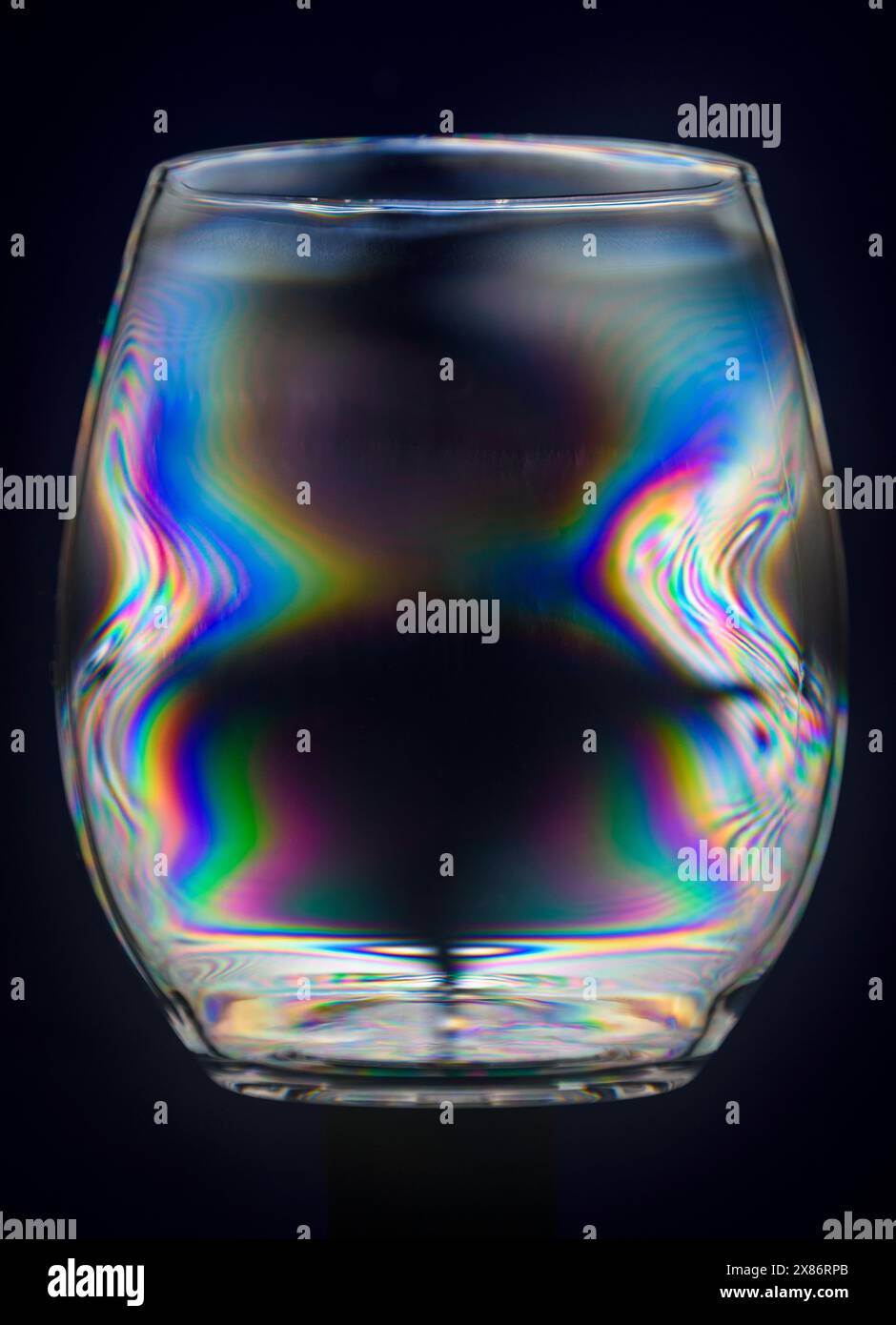 Bicchiere di plastica trasparente visibile tra i filtri polarizzanti incrociati. Foto Stock