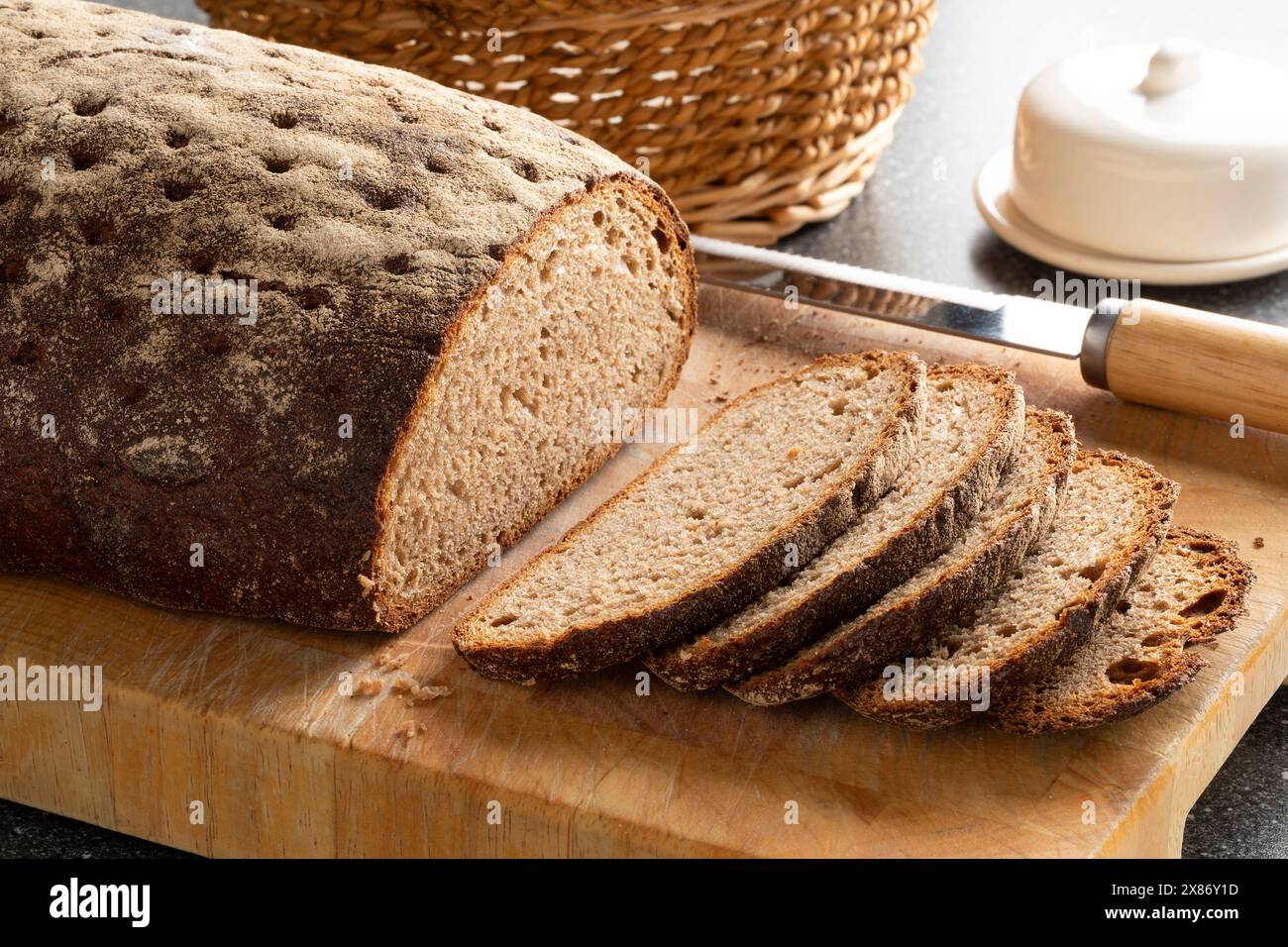 Per un pasto, il classico pane di segale misto a fette di pasta grossolana si avvicina su un tagliere Foto Stock