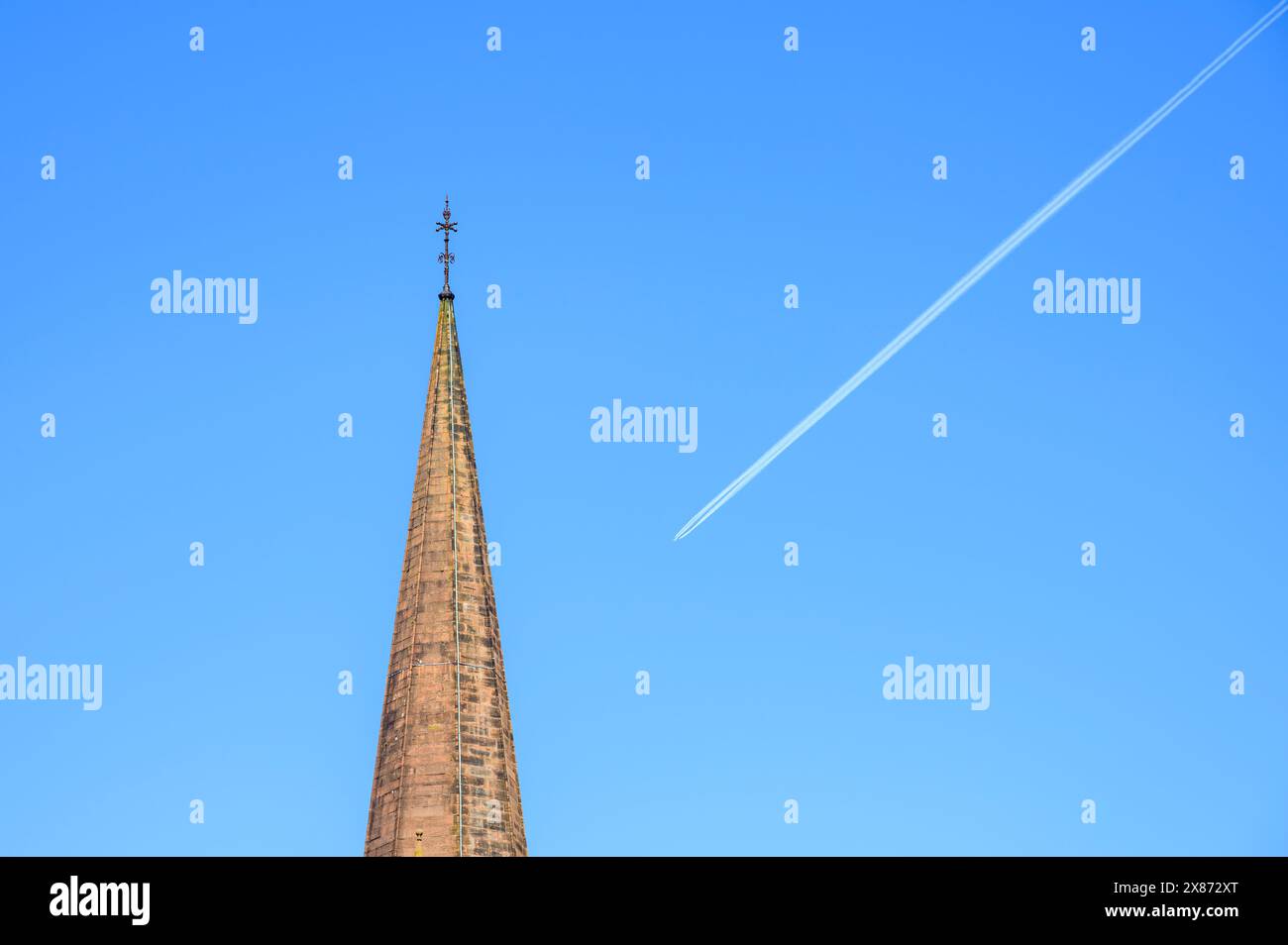 Campanile della chiesa con una pista di vapore aeroplano sullo sfondo Foto Stock