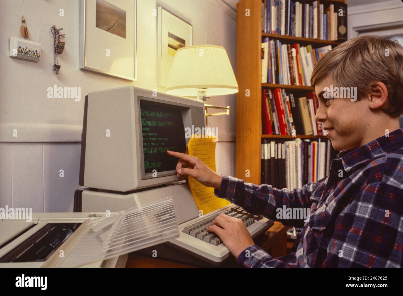Il ragazzo fa i compiti a casa sul computer Apple III Plus con stampante a matrice di punti nel 1986. (SIG.) Foto Stock
