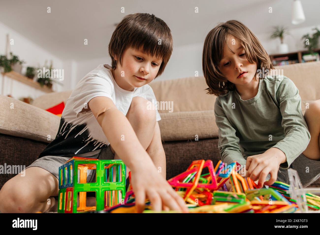 Fratelli che giocano con il giocattolo da costruzione a casa Foto Stock