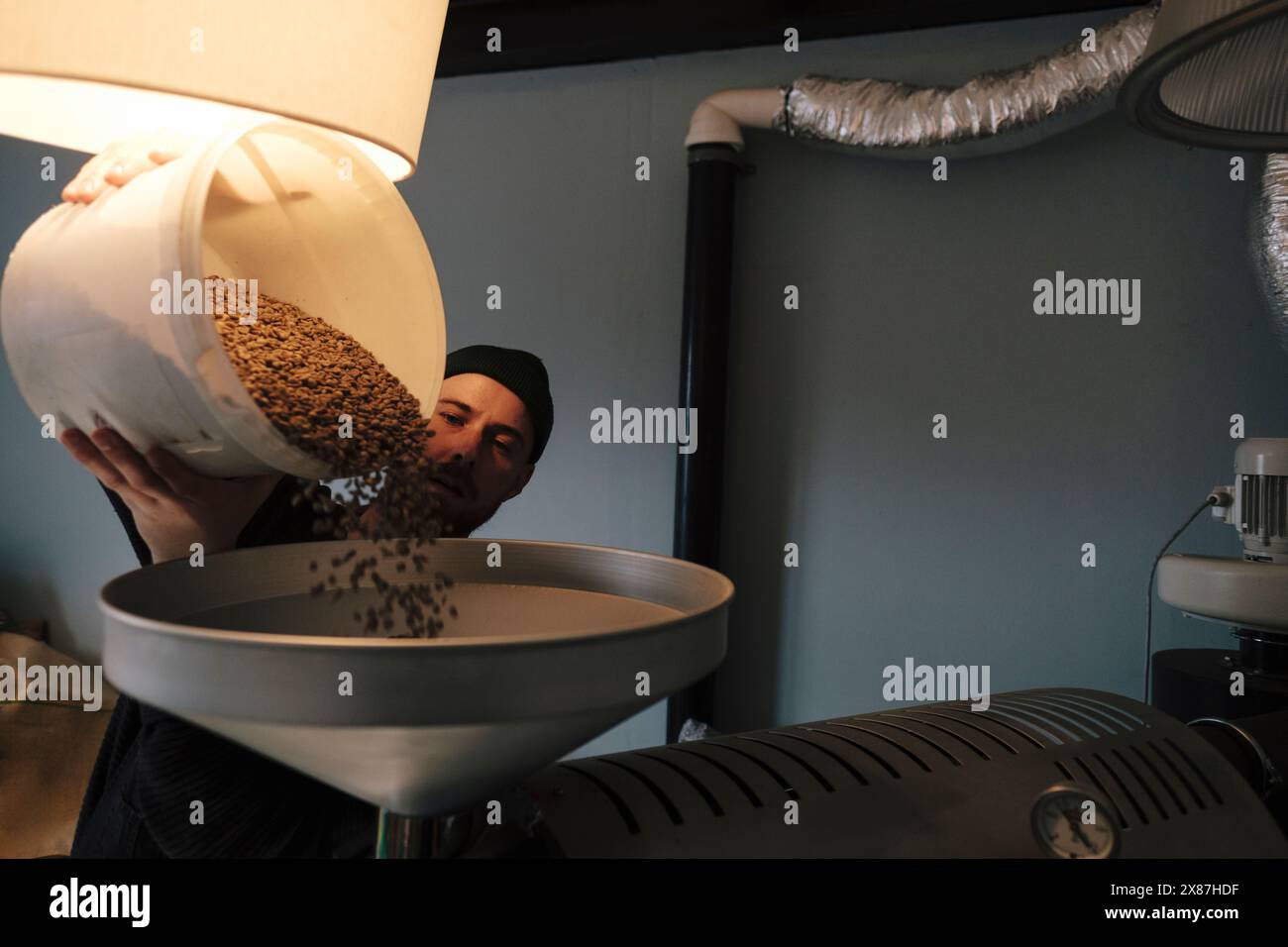 Tostapane per versare chicchi di caffè crudi in macchina Foto Stock