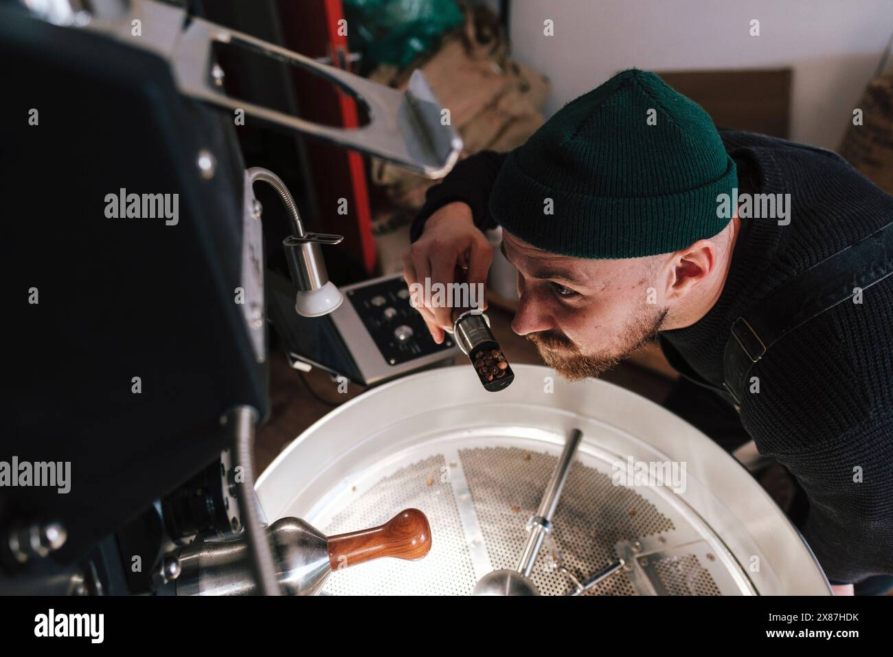 La torrefazione puzza di chicchi di caffè vicino al macchinario Foto Stock