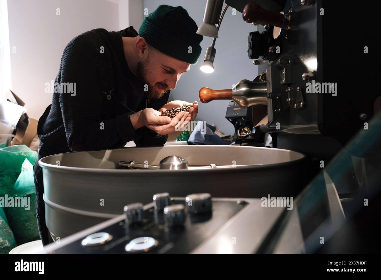 La torrefazione del caffè tiene e profuma i chicchi di caffè in fabbrica Foto Stock