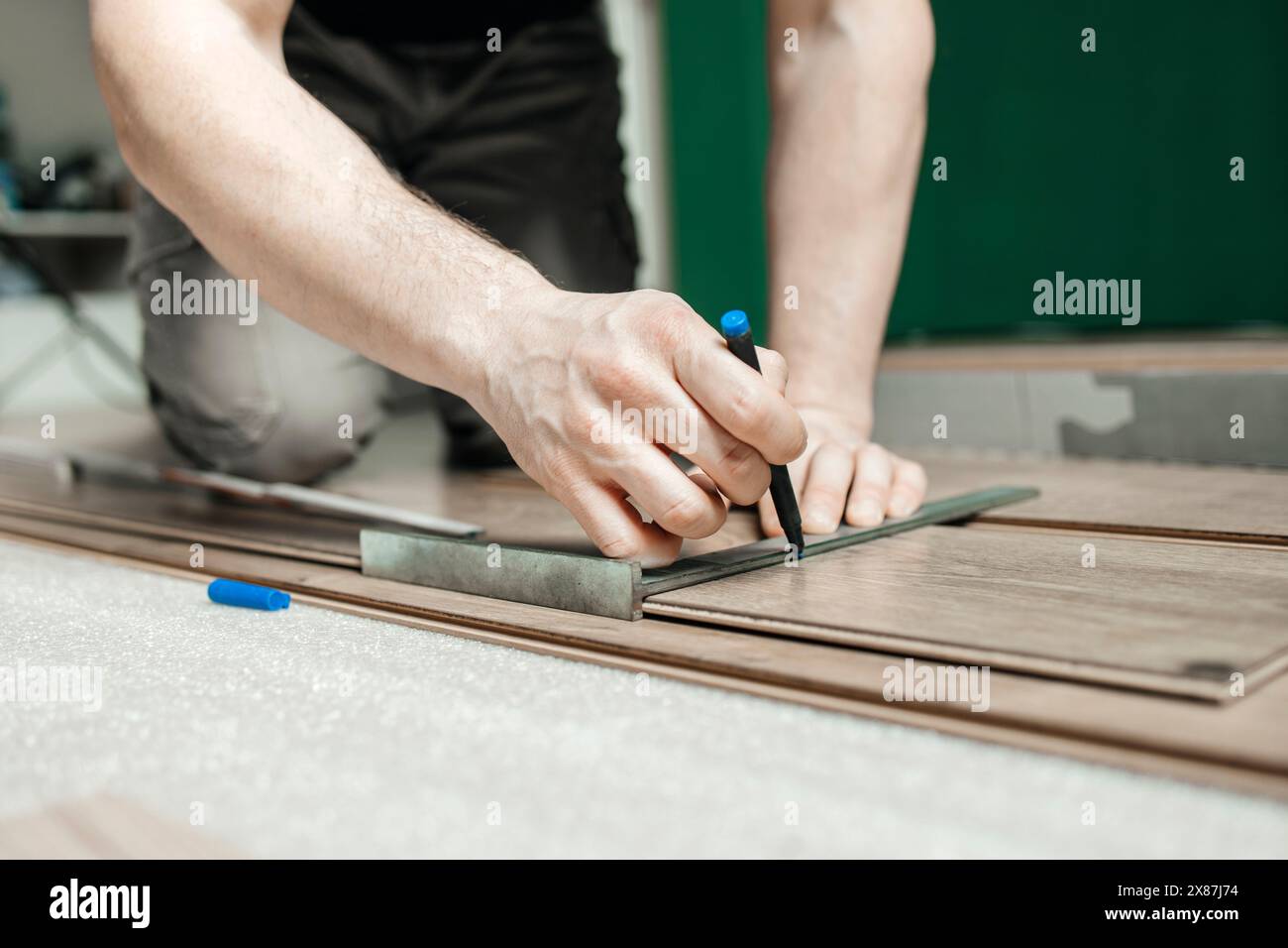 Uomo che contrassegna il pannello laminato sul pavimento di casa Foto Stock