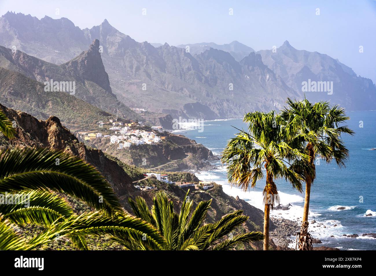 Spagna, Isole Canarie, Almaciga, costa montuosa dell'isola di Tenerife con villaggio sullo sfondo Foto Stock