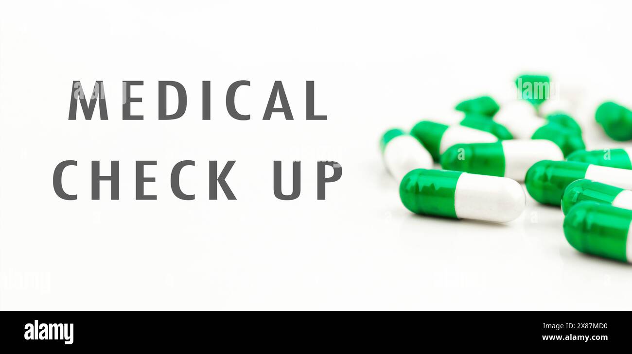Un mucchio di pillole con le parole controllo medico scritto su di loro. Le pillole sono verdi e bianche Foto Stock