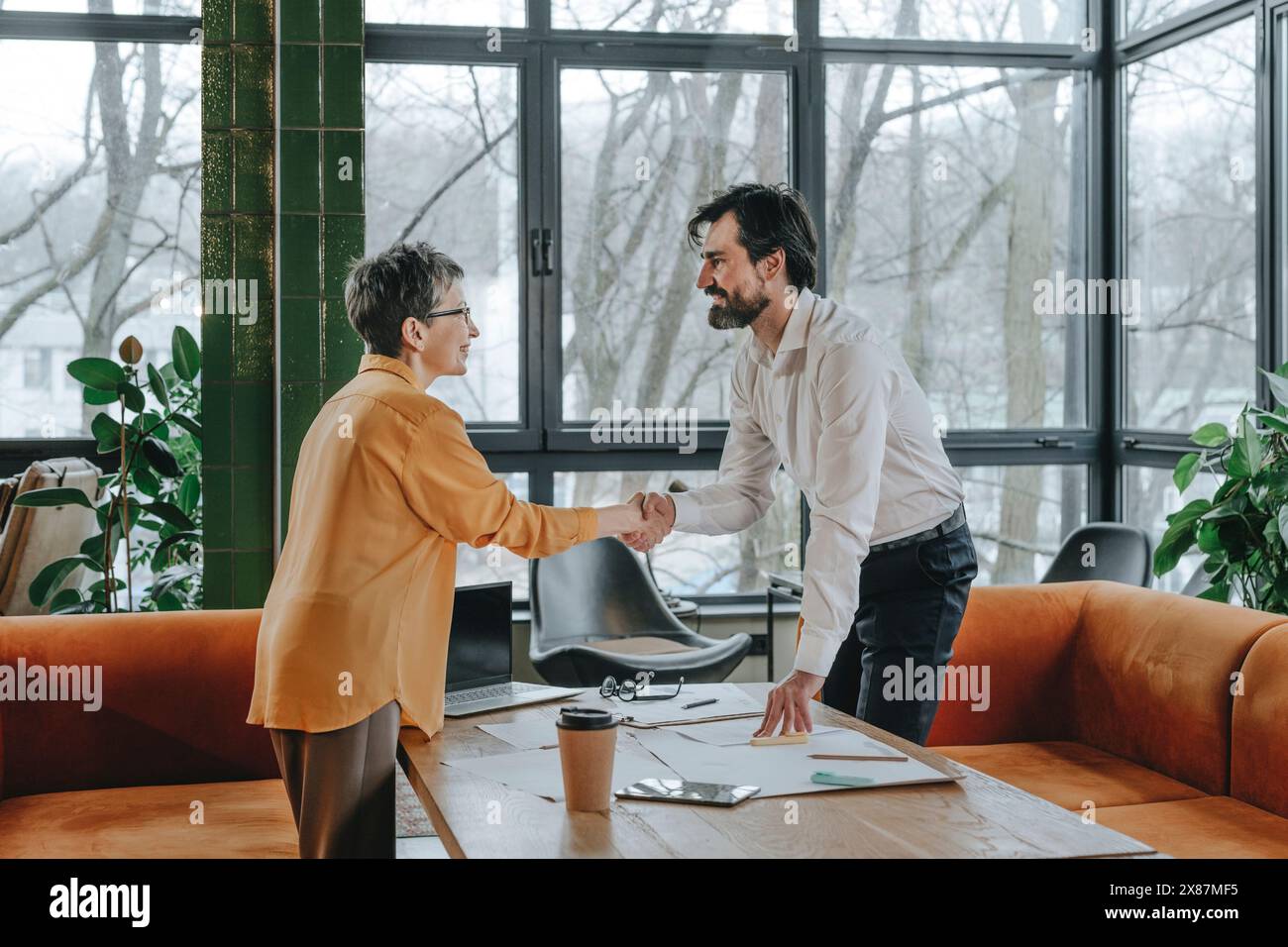 Sorridente la gente di affari si stringono la mano in ufficio Foto Stock