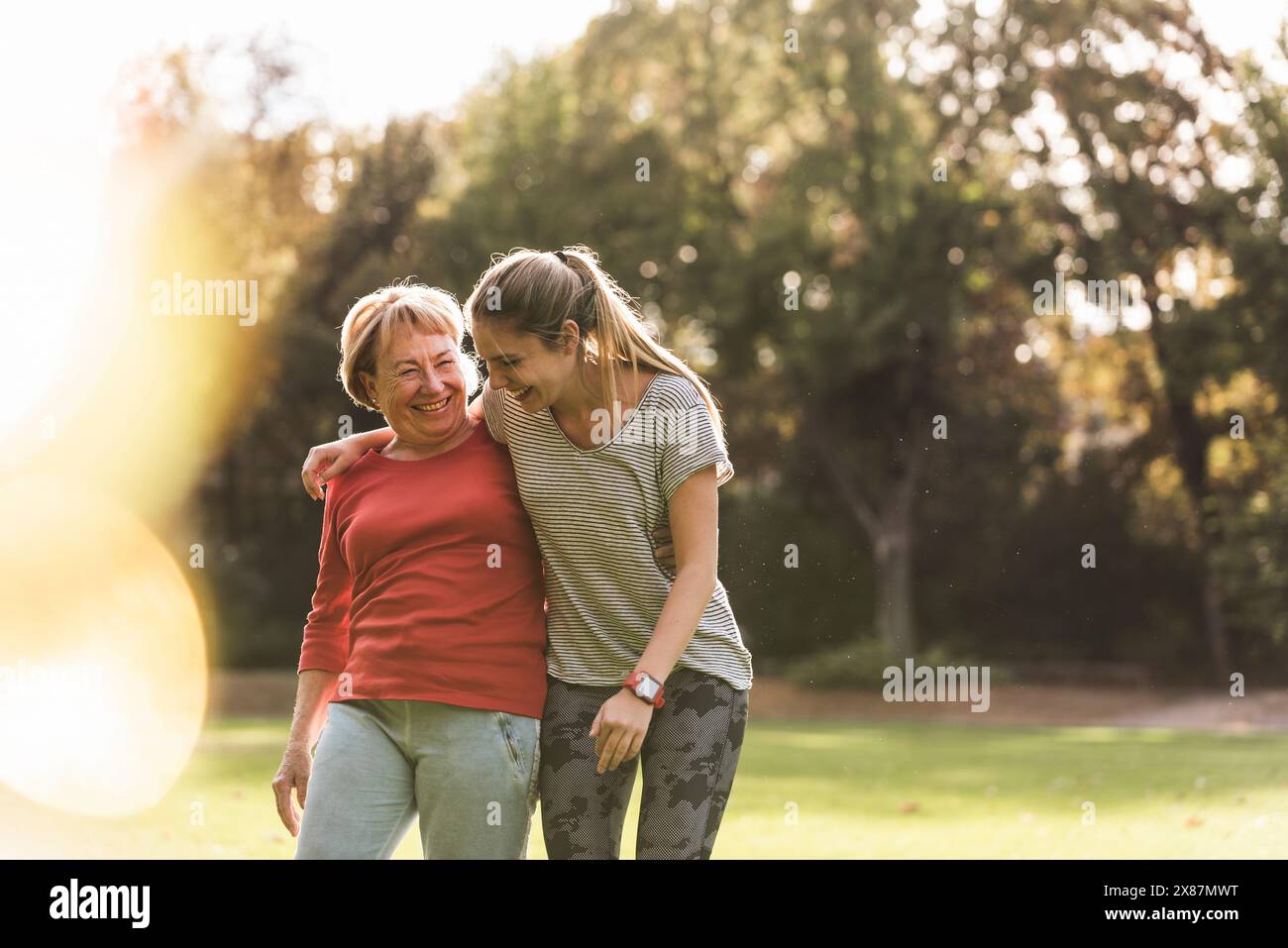 Giovane donna felice che cammina con la nonna nel parco Foto Stock