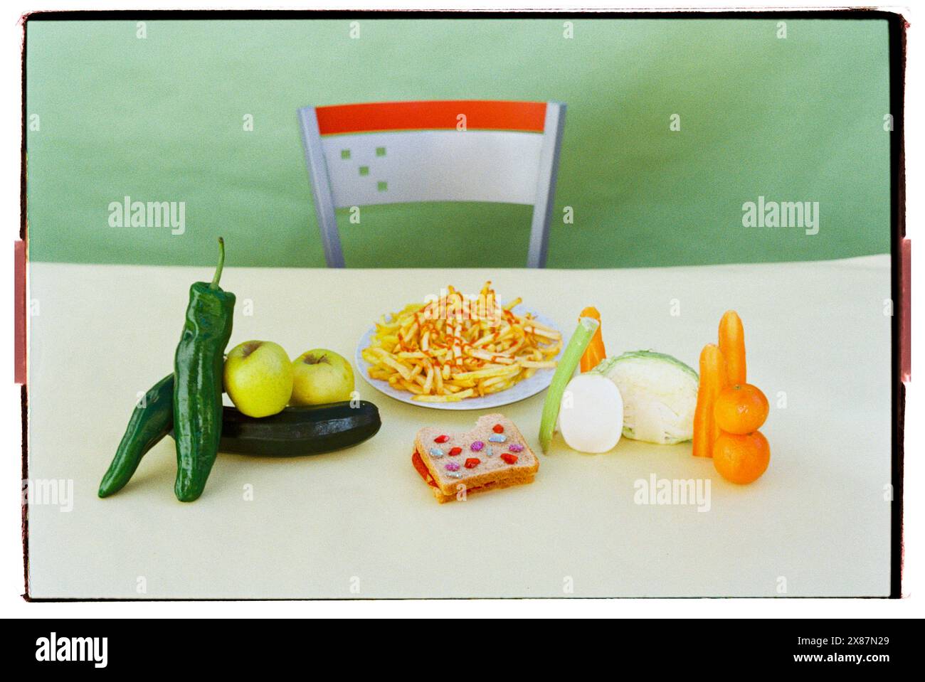 Piatto di patatine fritte vicino alle gemme sandwich con frutta e verdura varie sul tavolo Foto Stock