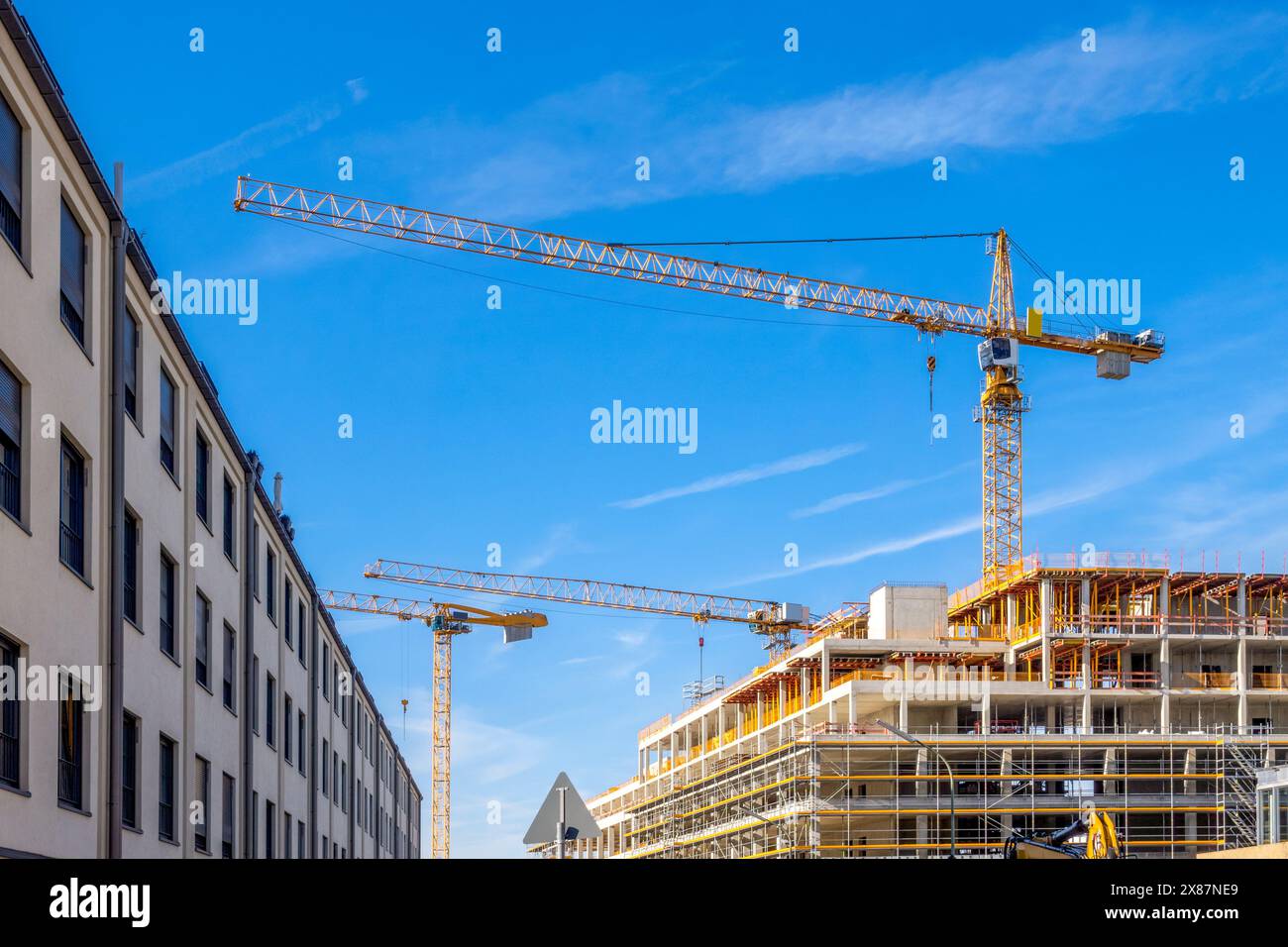 Germania, Baviera, Monaco di Baviera, gru industriali incombenti sul cantiere Foto Stock